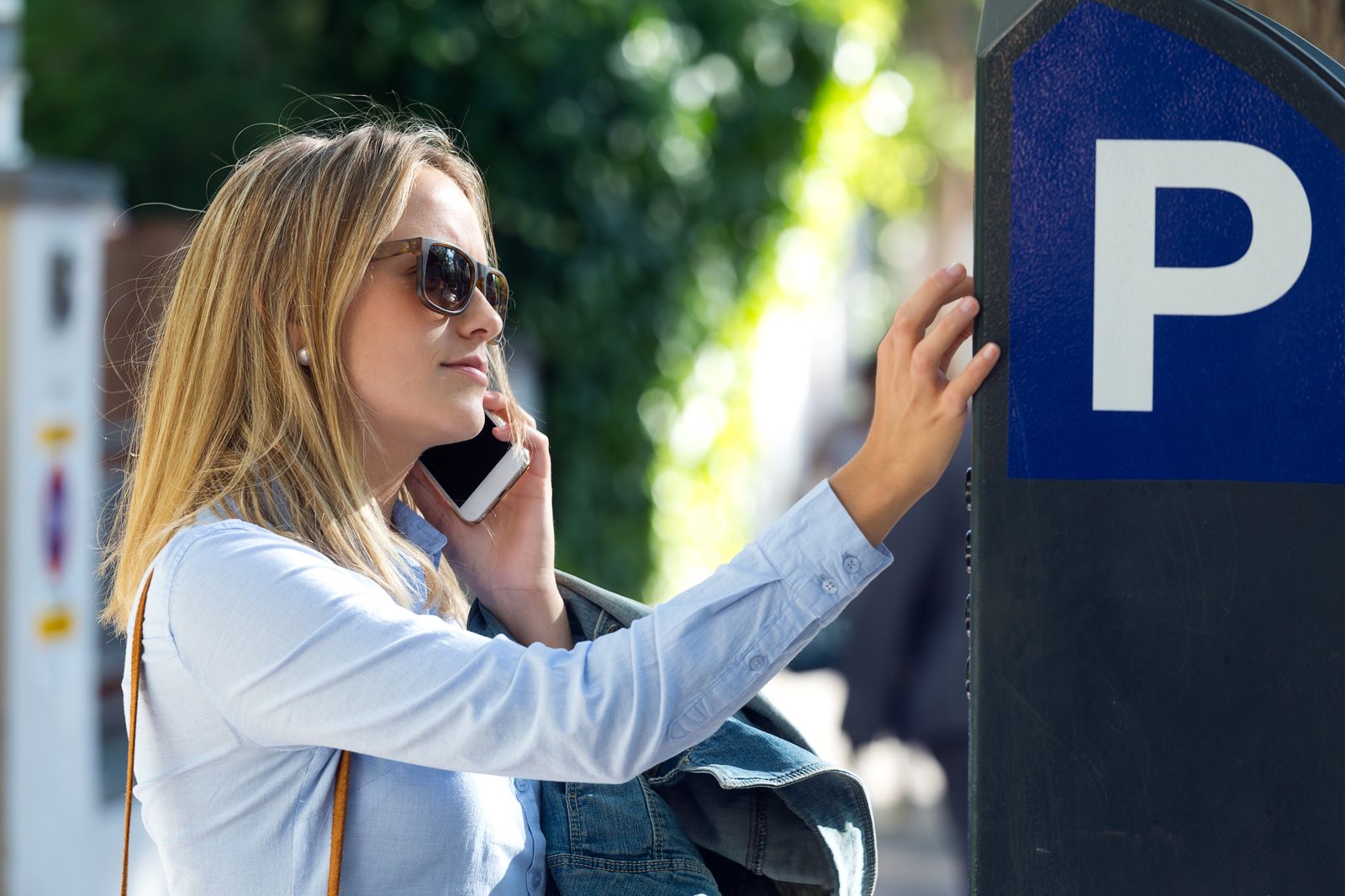 Lady paying for her parking at a parking meter.